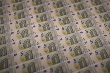 5 euro bills printed in illegal money production conveyor. Collage of many fake bills. Concept of...