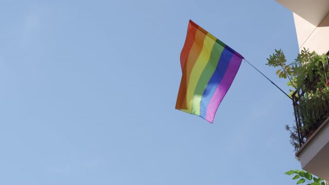 Gay pride rainbow flag hanging on a balcony and blowing in the wind on Sitges, in Barcelona province. Perhaps Spain top gay destination, with LGTB events like Gay carnival, pride and Gay Spring break.