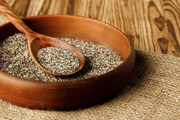 Chia seeds in a bowl with wooden spoon