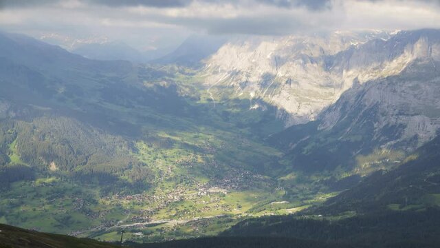 Beautiful clouds rolling over the green mountain village of Grindelwald in Lauberhorn, Swizerland - time lapse