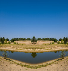 Fototapeta premium small lake among a sandy dunes, summer desert oasis scene