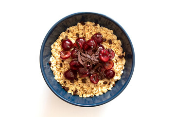 Blue bowl with oatmeal with cherry and chocolate isolated on white background.