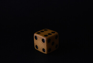 old and used six sided dice with a dark background