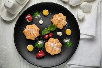 profiteroles cake with pistachio cream. On a white wooden table
