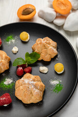 profiteroles cake with pistachio cream. On a white wooden table
