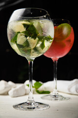 Assorted cold cocktails - mojito and raspberry. On a wooden, white table
