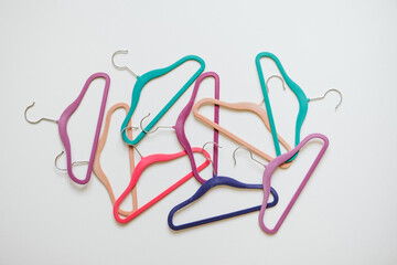 Sustainable responsible consumption concept. Many bright multi-colored velvet pop color hangers on white background. Store, sale, design, empty hanger