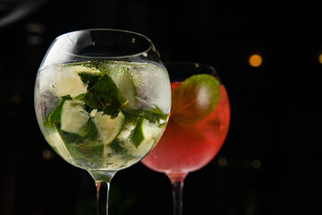 Assorted cold cocktails - mojito and raspberry. On a wooden, white table
