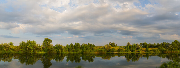 quiet summer river under a cloudy sky