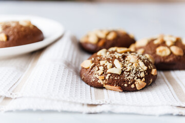 chocolate chip cookies with nuts and peanuts in a white tea plate on a table with a tea napkin