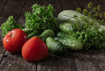 Fresh tomatoes, cucumbers, zucchini and lettuce on the table