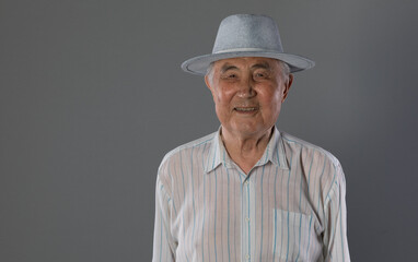 grandfather, pensioner, portrait of an old man on a gray background