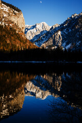 colorful clear reflection of the mountains in the lake in late winter in the alps