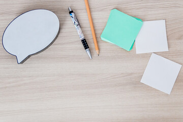 paper stickers and decorative dialogue on a wooden table with blank space