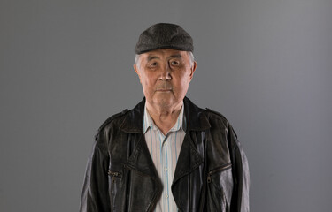 grandfather, pensioner, portrait of an old man on a gray background