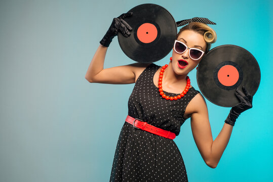 A photo of glamorous pin-up girl holding vinyl LP in hand