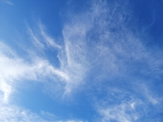 Cirrus clouds on blue sky background.