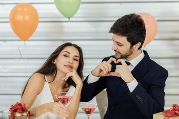 The caucasian couple enjoys drinking at a party.