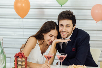 The caucasian couple enjoys drinking at a party.