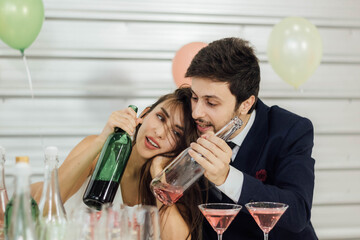 The caucasian couple enjoys drinking at a party.