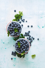 Fresh blueberries in a plastic containers on table. Top view, blank space