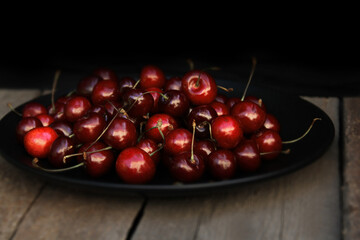 Beautiful juicy cherries on a wooden background. Summer berry. Juicy fruits. Vitamins