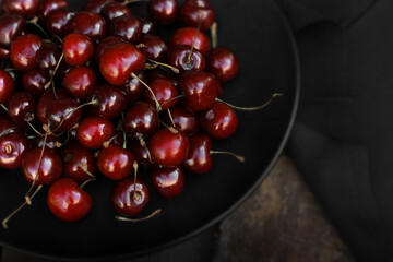 Beautiful juicy cherries on a wooden background. Summer berry. Juicy fruits. Vitamins. Close up