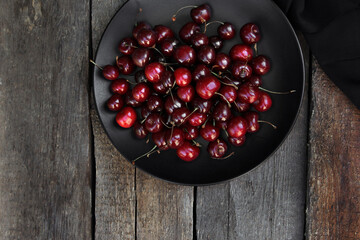 Beautiful juicy cherries on a wooden background. Summer berry. Juicy fruits. Vitamins