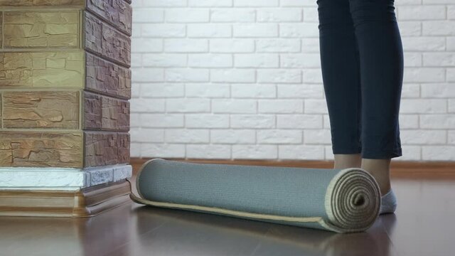 Calm yoga at home. The girl spreads the yoga mat.