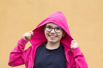 portrait of hipster girl with hoodie and glasses on the street