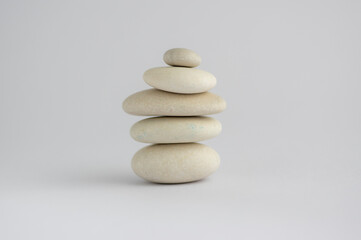 One simplicity stones cairn isolated on white background, group of five white pebbles in tower