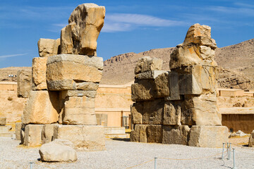 Ruins of Apadana and Tachara Palace behind stairway with bas relief carvings in Persepolis UNESCO World Heritage Site against cloudy blue sky in Shiraz city of Iran. Middle East, Asia