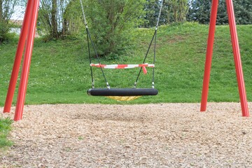 Corona virus quarantine lockdown prohibit playground swings. Closure by barrier tape. Covid-19...