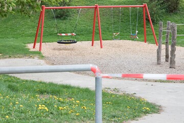 Corona virus quarantine lockdown prohibit playground swings. Closure by barrier tape. Covid-19...