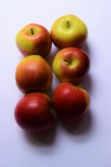 Fototapeta na wymiar Six ripe red and green Braeburn apples on light background with copy space