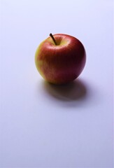 One ripe red and green Braeburn apple on light background with copy space