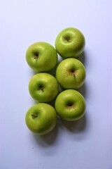 Six ripe green Granny Smith apples on light background with copy space