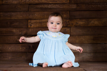 Beautiful girl in blue dress on wooden background