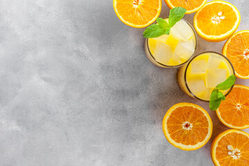 Chilled Orange Juice with Ice on gray stone background top view flat lay copy space
