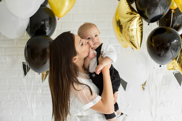 Young mother and son with balloons. Birthday