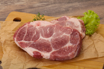 Raw pork steak over wooden board