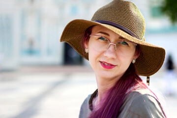 Young beautiful cute young elegant girl in a beautiful hat and glasses looking at the camera, beautiful face, expressive eyes, posing in an urban area on an autumn day, outdoors, stylish hat and