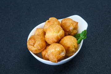 Sweet tasty profiteroles heap in the bowl