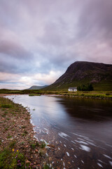 A view of Lagangarbh cottage in Glen Coe on rannoch moor in the argyll region of the highlands of Scotland during a summer evening