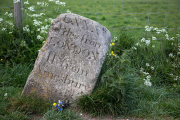 Old milestone at Stonehenge, UK. showing distance to London and Amesbury in roman digits