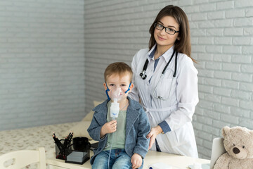 .Medical doctor applying medicine inhalation treatment on a little boy with asthma inhalation...
