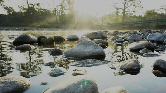 Sun rays from a rising sun in the morning, falling and reflecting on river water. Shot at Murti river, Dooars, West Bengal, India. Murti river is a popular tourist place.