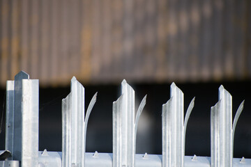 A metal fence surrounding an agricultural barn