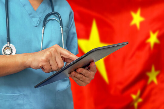 Surgeon Or Doctor Using A Digital Tablet On The Background Of The China Flag. Medical Equipment Or Medical Network, Technology And Diagnostics In China.