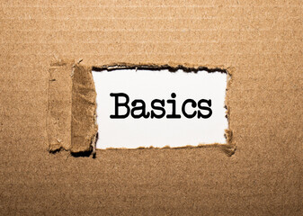 The text BASICS. behind torn brown paper